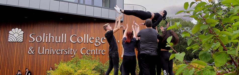 students throwing another student into the air